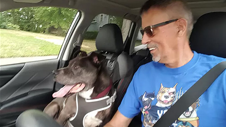 Doug Sears smiling in the car with Ceasar, the shelter dog he helped get adopted after five years